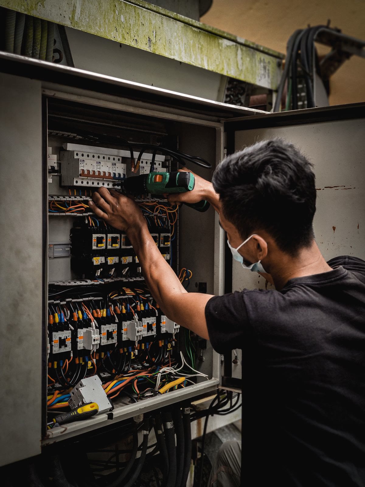 An electrician working on a home's breaker panel